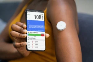 woman holding a cell phone and measuring glucose on an app.