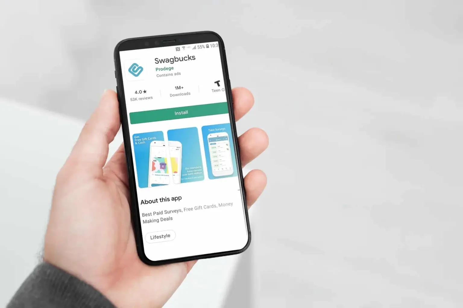 hand holding cell phone, showing the app to earn money by watching videos, swagbucks